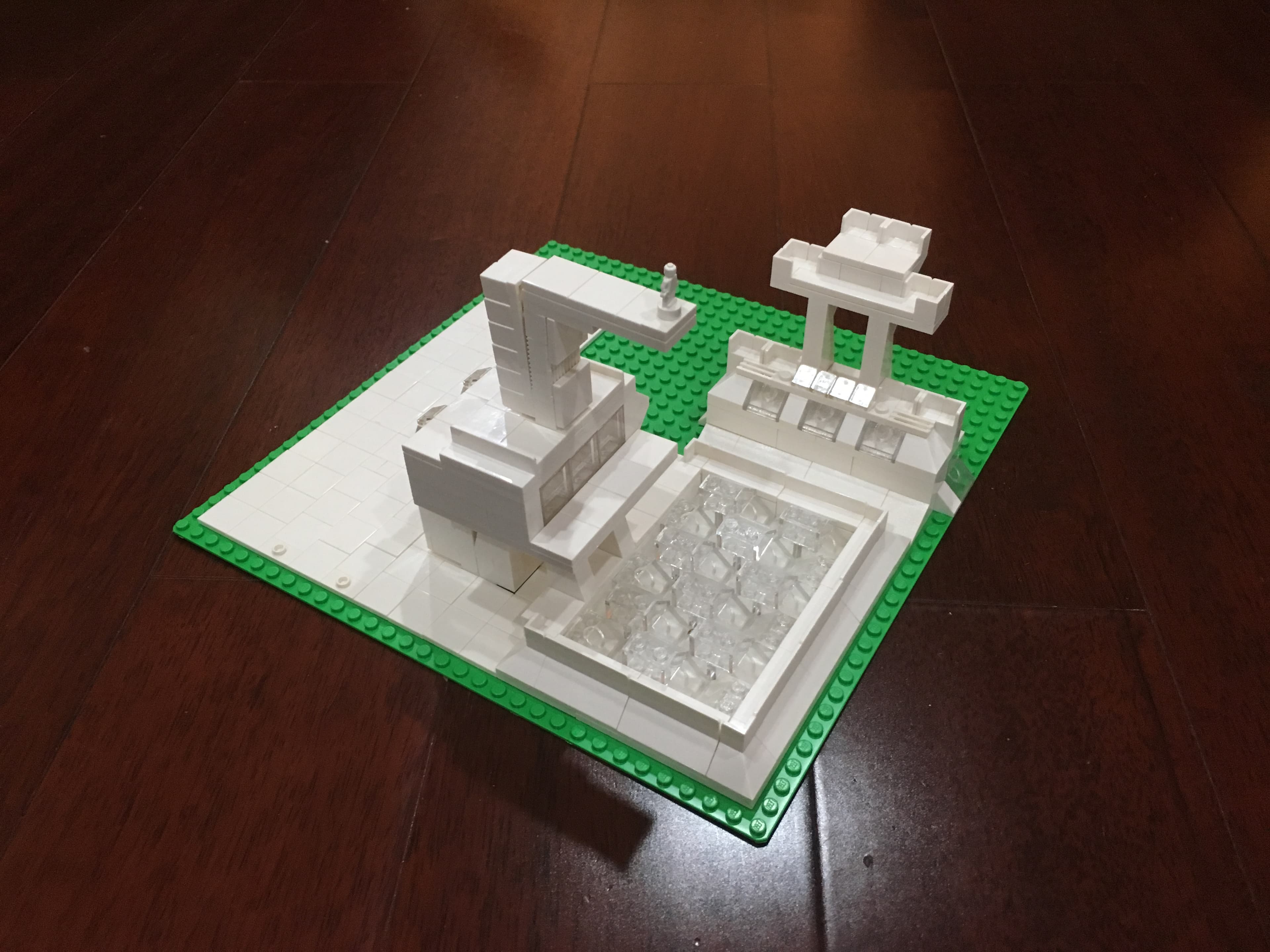 White LEGO landscape with a central tower on a green base plate.