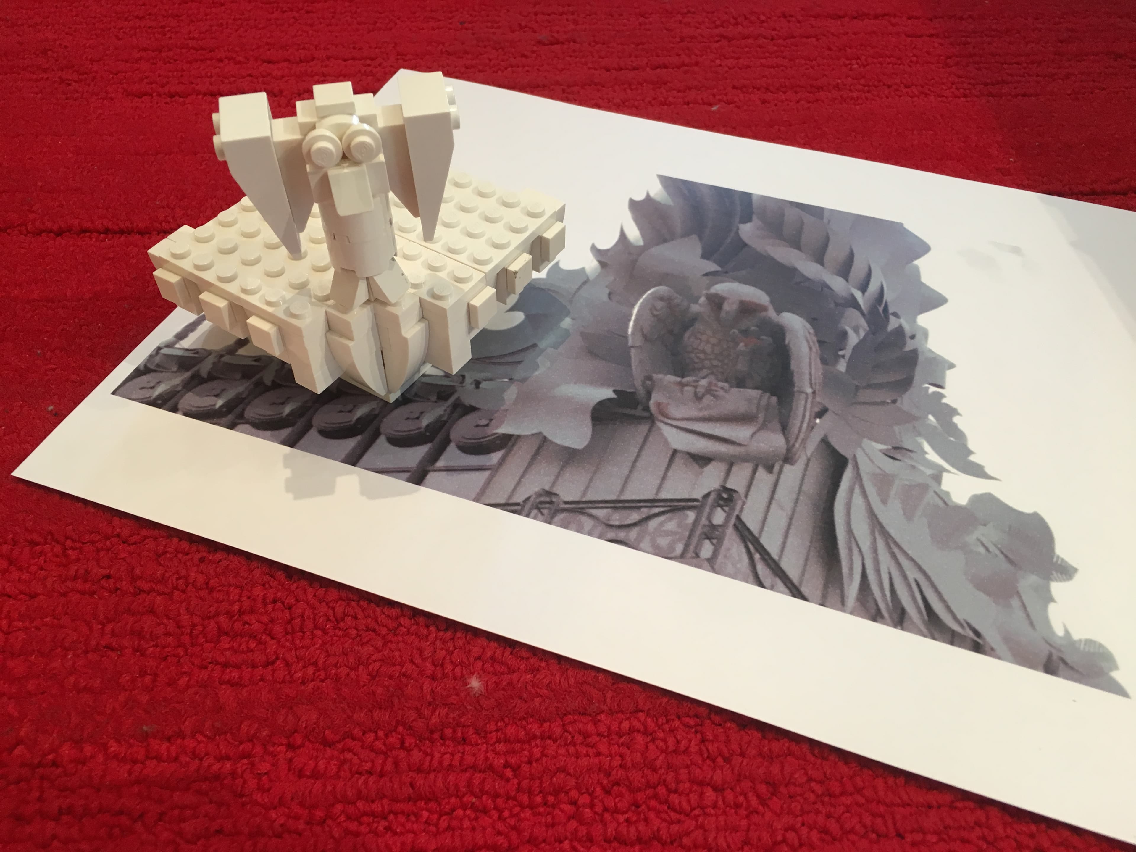 White LEGO model displayed over an architectural reference image.