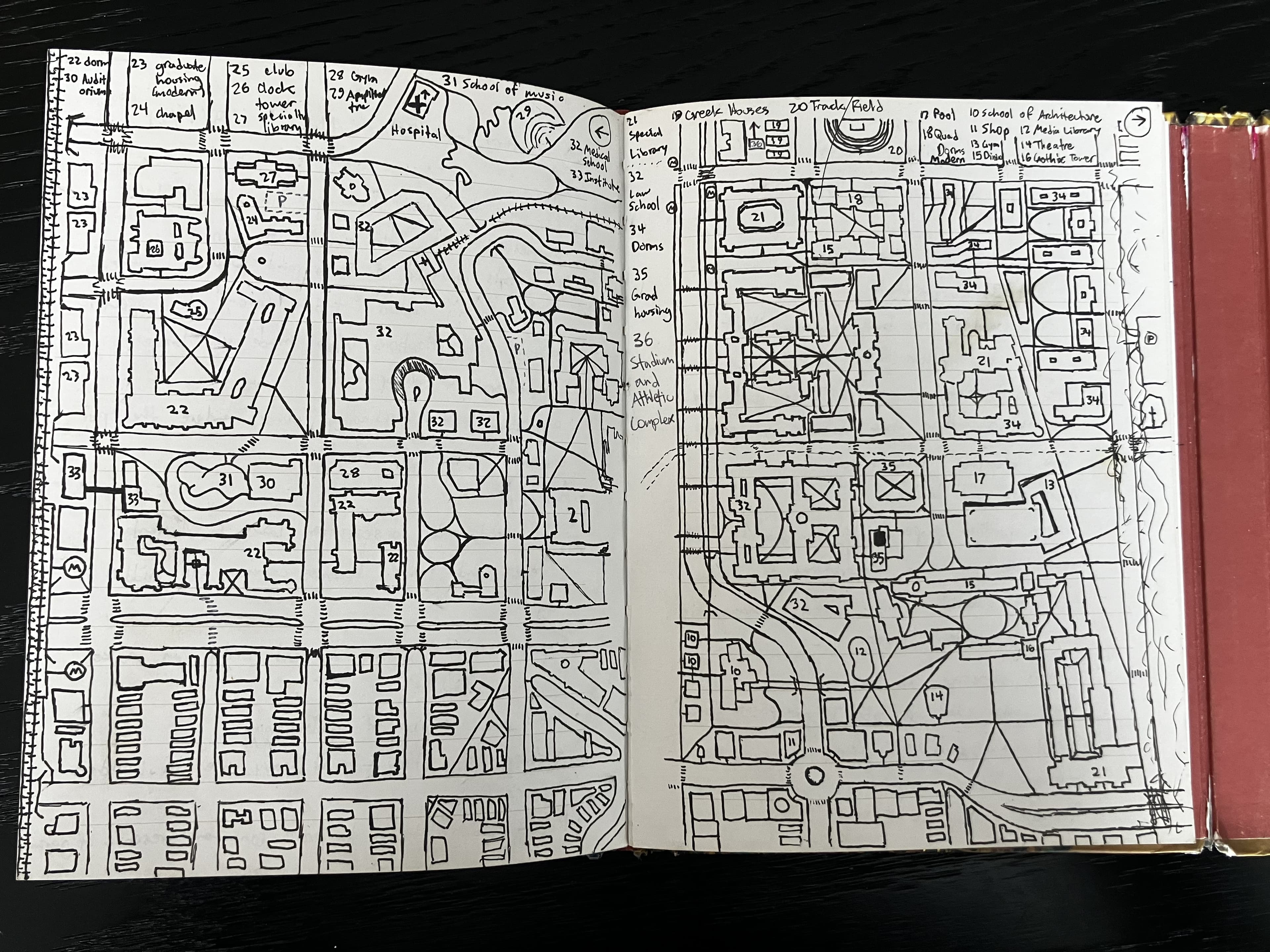 Open sketchbook with a hand-drawn campus and city map.